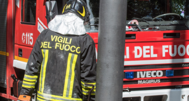 Foto di un vigile del fuoco di fronte a un veicolo antincendio